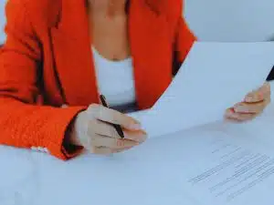 Woman signing documents to switch financial advisers