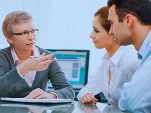 Couple meeting with financial adviser, learning the difference between free vs paid financial advice in Australia
