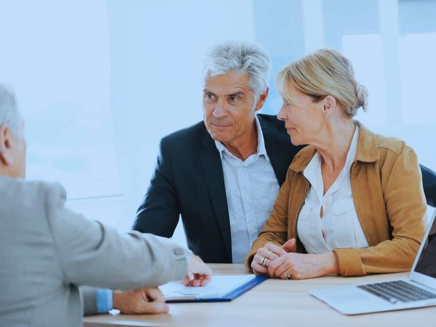 How to maximise super with a financial adviser featured image, showing a mature couple working with a financial planner